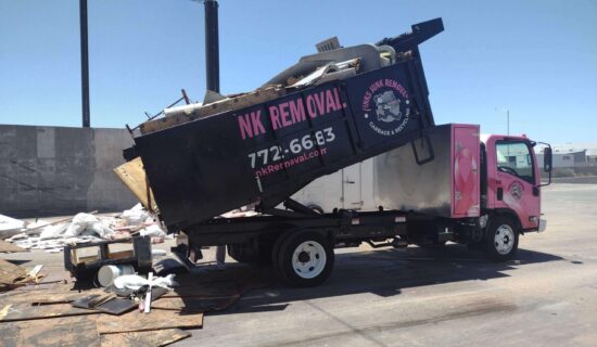 A purple and pink dump truck unloading debris outdoors. A purple and pink dump truck unloading debris outdoors.